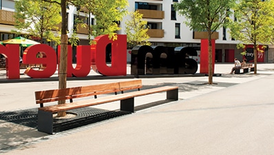Bench with modular backrest in steel and wood to create customized, colorful street furniture to liven up urban spaces and landscapes.
